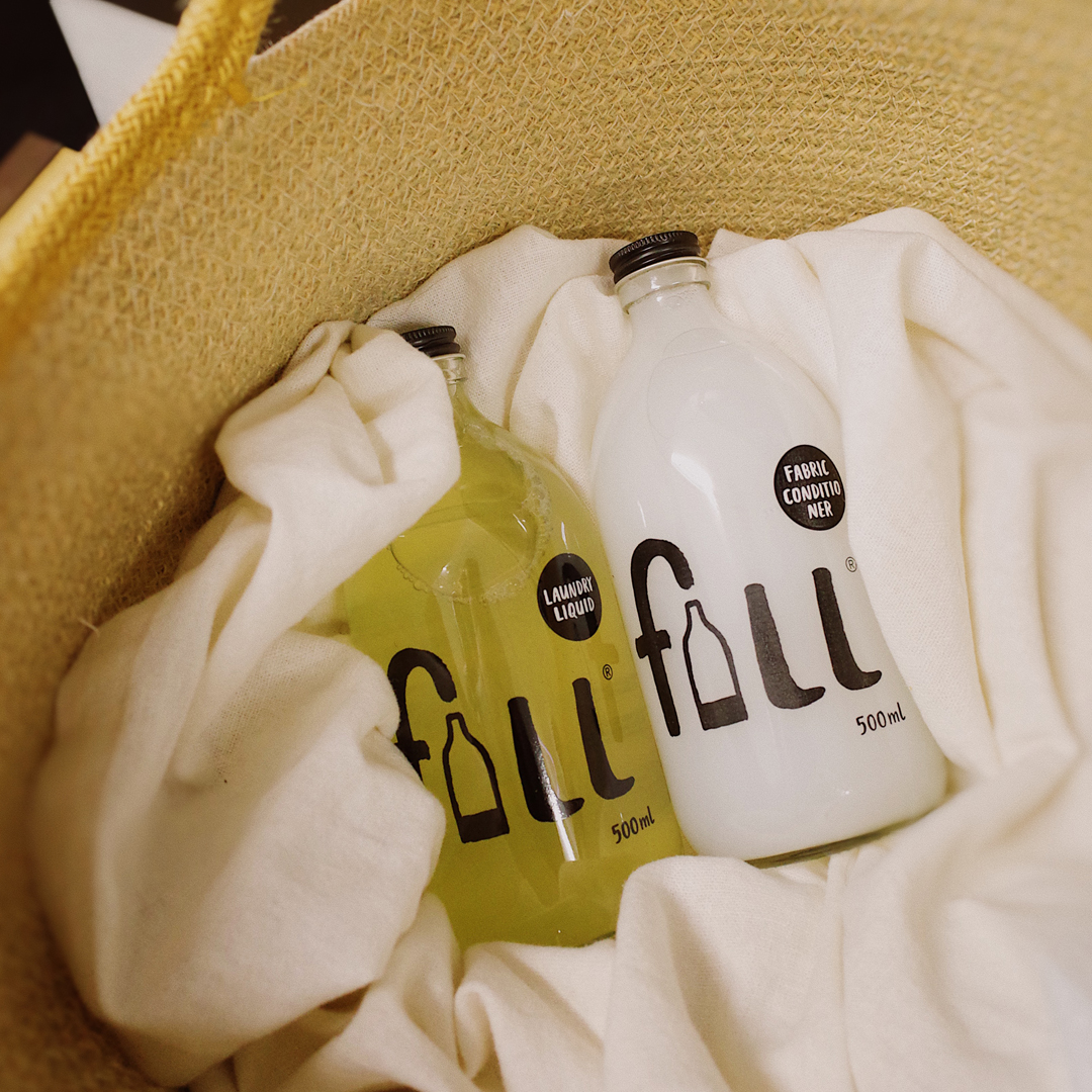 Laundry liquid and fabric conditioner bottles inside a laundry basket